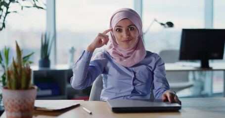 Fototapeta premium Portrait of angry arabic businesswoman in hijab sitting at office shouting and kicking out employee. Emotional female boss. Expressions.