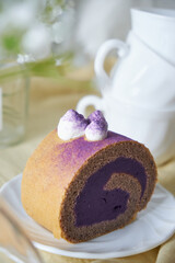 Swiss Roll Cake with sweet purple potato filling set on cafe table.