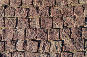 Pavement rocks, stones and cobblestone blocks, construction of path, road or sidewalk. Abstract background, granite texture, top view.
