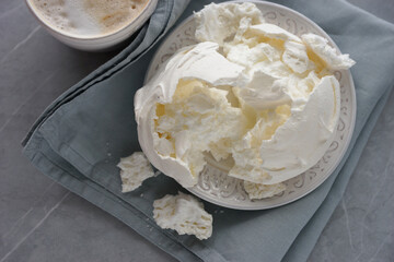 Large meringue on a plate and a blue napkin