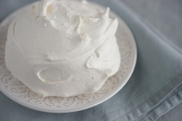 Large meringue on a plate and a blue napkin