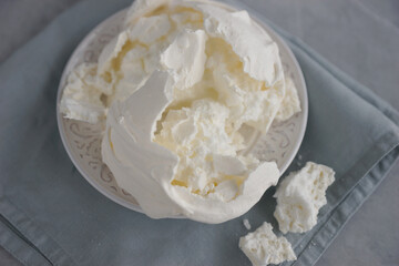 Large meringue on a plate and a blue napkin
