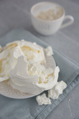 Large meringue on a plate and a blue napkin