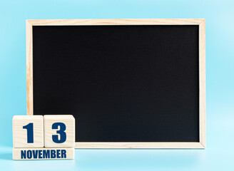 November 13. Day 13 of month, Cube calendar with date, empty frame on light blue background. Place for your text. Autumn month, day of the year concept