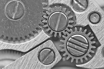 Black-and-white background with metal gear wheels of the old clockwork. Conceptual photo for successful business design. Macro.