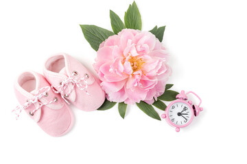 Obraz na płótnie Canvas Pink baby girl shoes with peony flower and alarm clock on a white background. Newborn greeting card or invitation. Copy space. Flat lay.