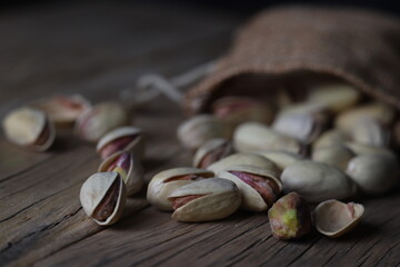 salted pistachios in their shells scattered on the table
