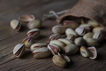 delicious pistachios in a shell on a textured wooden table