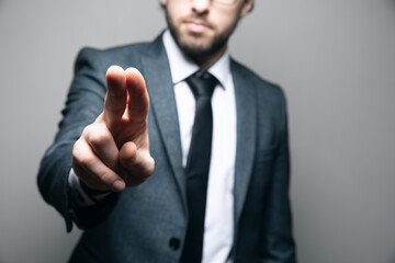 a man in a suit and glasses clicks on a virtual screen