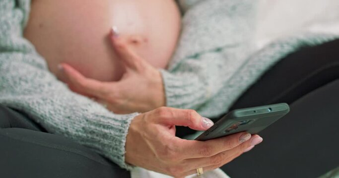 Young pregnant woman scrolling pictures phone. surfing internet. A caring mother strokes a naked pregnant tummy hand.