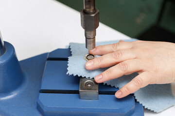 Machine puts a rivet on the fabric