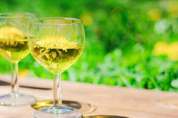 two glasses of dandelion drink. Dandelion meadow, romantic summer background.