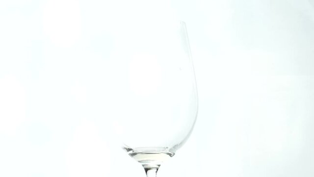 Pouring white wine in glass isolated on white 