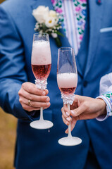 Glasses with red wine in the hands of the newlyweds and their friends