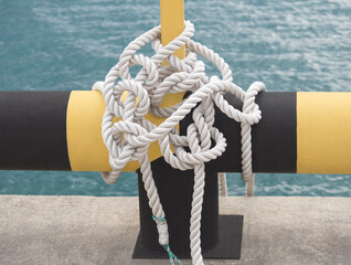 Fototapeta premium White rope tied in reef knot in sea dock