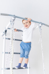 child boy on the Swedish wall or sports complex climbs at home, the concept of children's sports