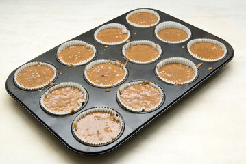Raw dough into muffins in the forms