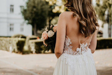 Fototapeta na wymiar bride holding bouquet with flowers in white wedding dress on her wedding day 