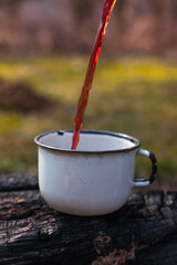 Take an enamel glass for tea or cocktails with you and on the road. For layout, nature background. 