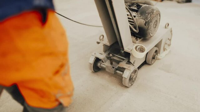 Workers grind the concrete floor at the construction site.