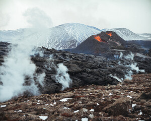 Hot lava is erupting from the volcano in Iceland in April 2021, smoking lava fields around the...