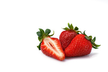 Three strawberries with leaves isolated on a white background.