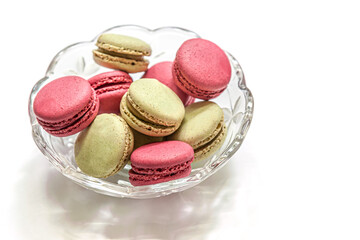 raspberry and pistachio macaroon cakes in a glass bowl isolated on white