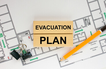 Construction drawings and wooden bars with text Evacuation Plan and paper clips