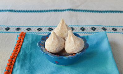 Traditional Greek almond cookies amygdalota in  a bowl on the Greek blue kitchen cloth