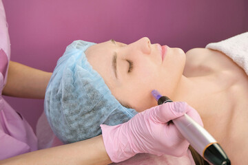 Needle mesotherapy. Cosmetologist performs needle mesotherapy on a womans face.