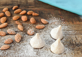 Fototapeta na wymiar Traditional Greek almond cookies amygdalota with powdered sugar and almonds on the wooden background