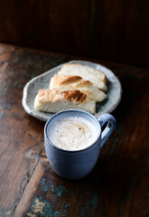 Cappuccino and sweet bun on dark wooden background. Close up. 