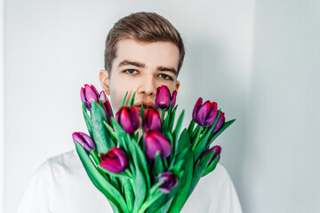 Tender tulips for her. Man, guy with tulips bouquet