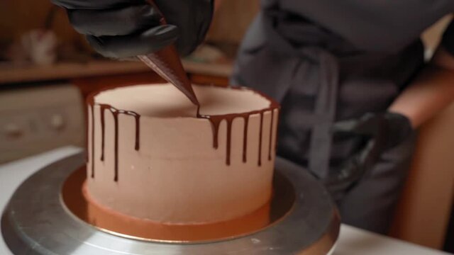 The cake is poured with hot chocolate from the confectionery bag