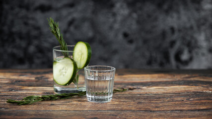 Bebida mexicana de agave mezcal tipo tequila hecha en oaxaca servida en veladora oaxaqueña sobre mesa de madera rústica acompañada de limón y sal de gusano 