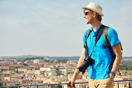 man traveler in a hat with a backpack and camera