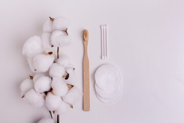Bamboo toothbrushes and ear sticks, cotton sponges and cotton flowers. Personal care tools for protect oral cavity, face and ear care on white.