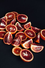 sicilian orange cut into pieces.
citrus, vitamins, on a dark background. wooden board. Healthy Eating.
food for rest. vegetarianism