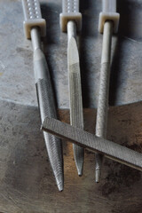 several metal files are on the metal surface. close-up.