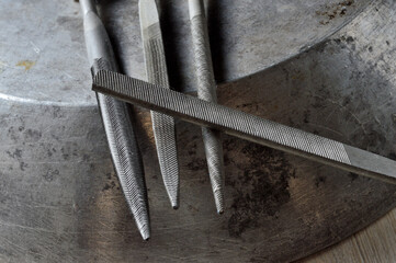 several metal files are on the metal surface. close-up.