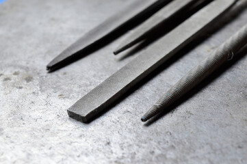 several metal files are on the metal surface. close-up.
