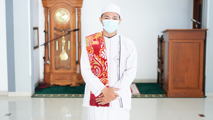 A portrait of an asian muslim man stylish at mosque, after sholat, wearing mask