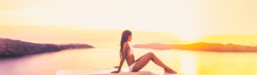 Europe Luxury vacation beach woman relaxing in sunset at Santorini hotel resort swimming pool ,...