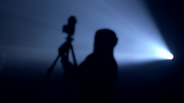 silhouette of the photographer in the backlight of the projector
