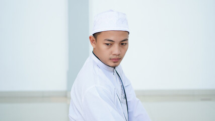 A portrait of an asian muslim man pray at mosque, the pray name is sholat, regards end of sholat