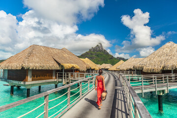 Tahiti luxury hotel honeymoon travel vacation tourist woman walking at luxury resort in overwater bungalows villas. View of Mount Otemanu, Bora Bora, French Polynesia - 427750502