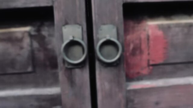 Dolly zoom in chinese style old wooden doors and the metal doors knobs on it