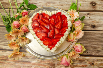 Close-up of a heart shaped strawberry cake on a wooden background