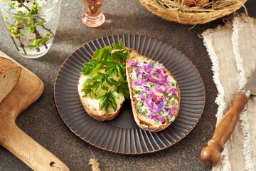 Slices of sourdough bread with butter and wild edible spring plants - goutweed, purple dead-nettle and lungwort