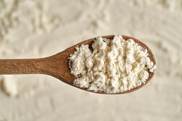 Whey protein powder on a wooden spoon